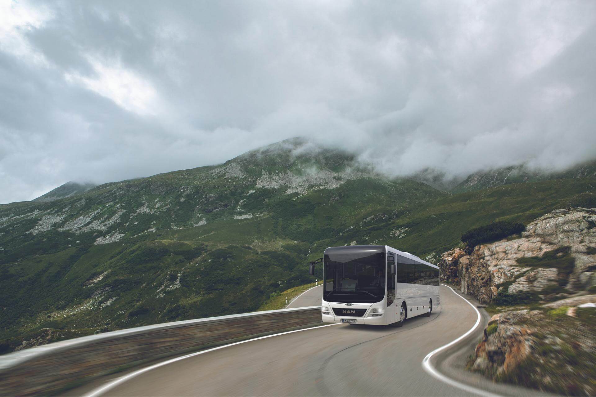 Bus auf einer Straße mit Bergen im Hintergrund